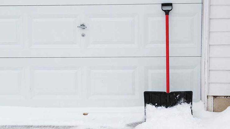 Snow shovel next to garage door.