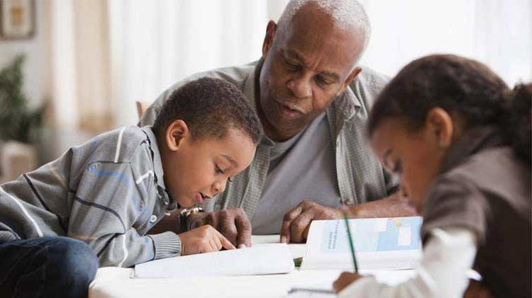 Man doing school work with children at the table.