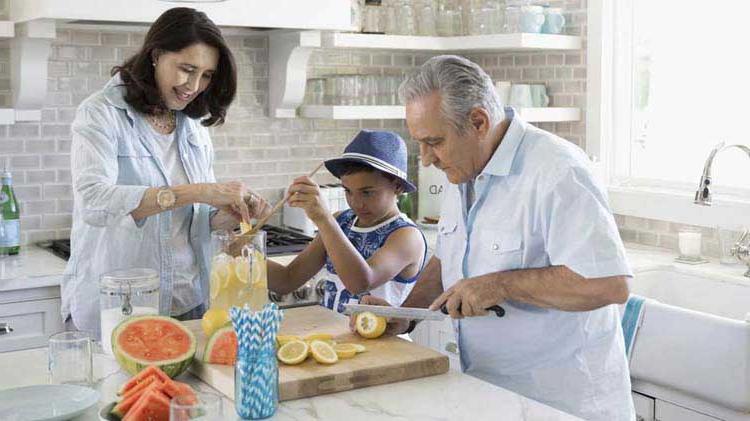 Family cutting up fruit in the kitchen.