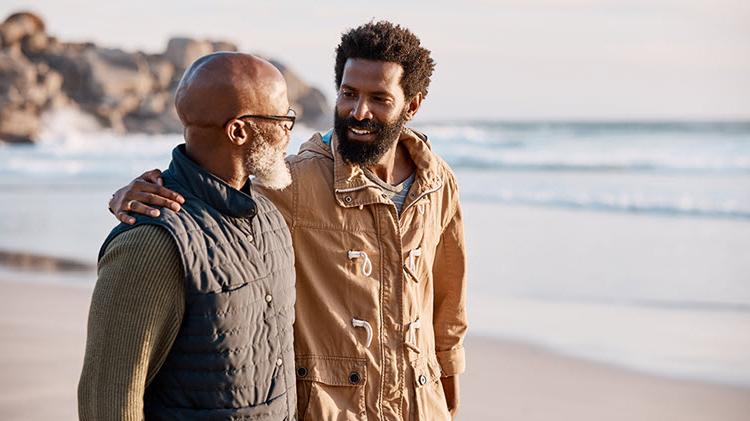 Father and son walk together on the beach and talk about money.