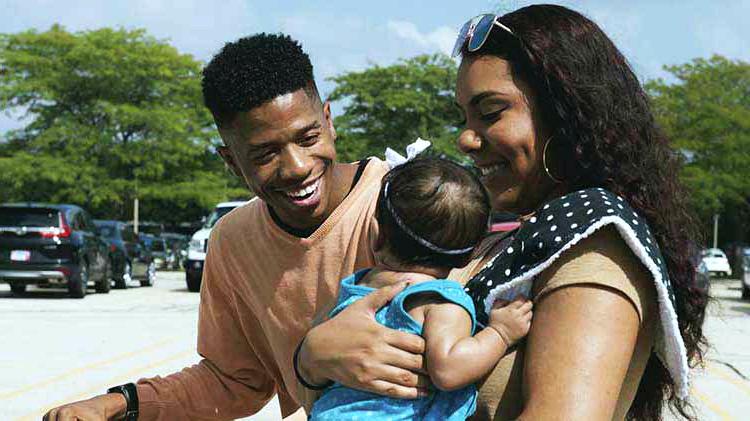 Man and woman holding baby.