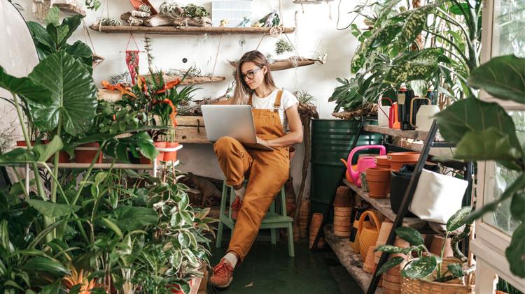 Small business owner sitting among her many plants.