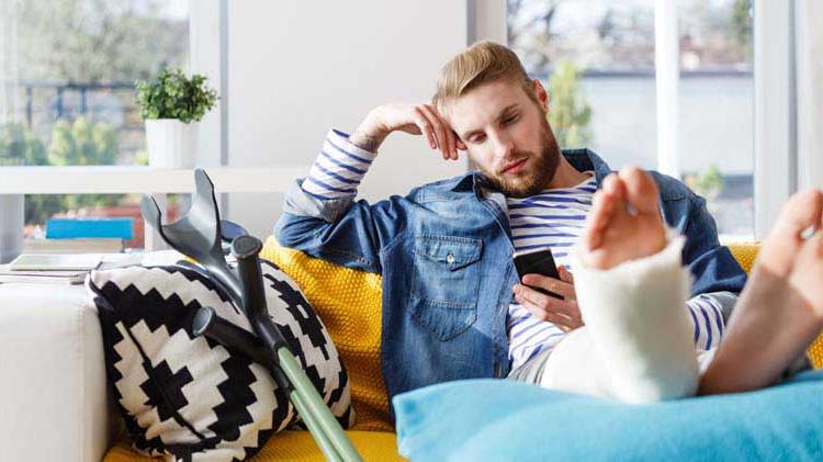 Man with an injury looking at his disability insurance benefits on his phone