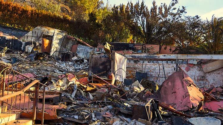 A home is completely destroyed by a wildfire.